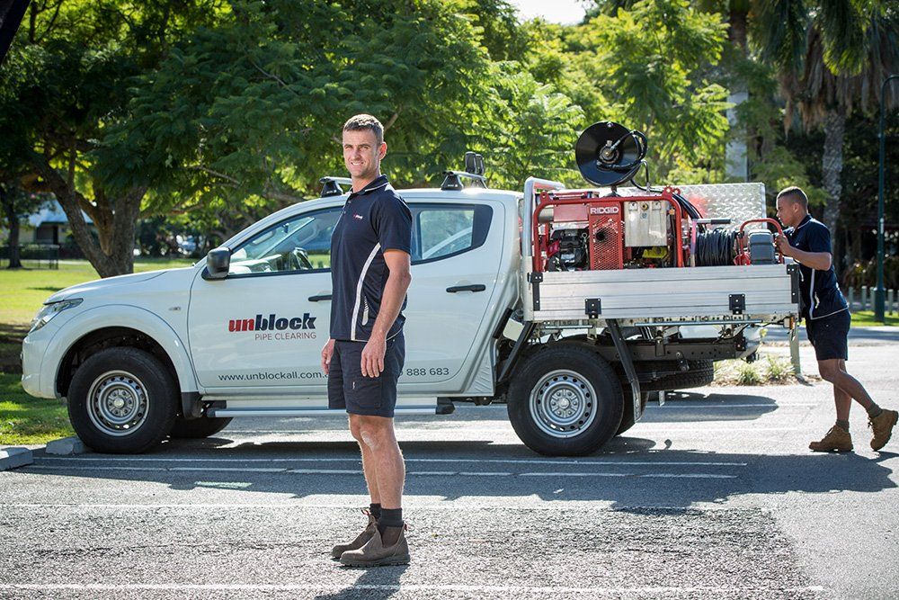 Plumber Standing In Front of their Service Vehicle — Unblock Pipe Clearing in Tweed Heads, NSW