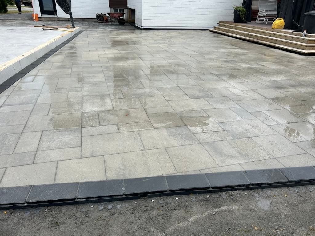 Une allée en briques est en cours de construction devant une maison.