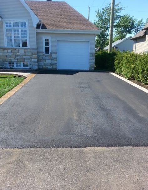 Une allée menant à une maison avec une porte de garage