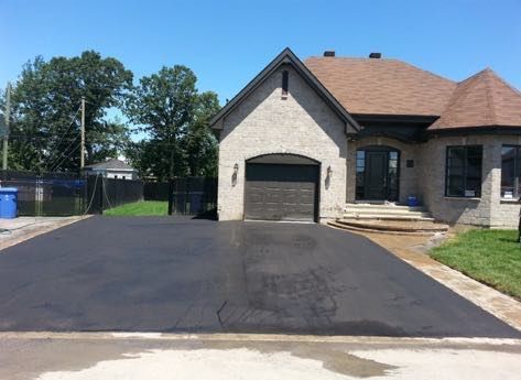 Une maison avec un garage et une allée devant