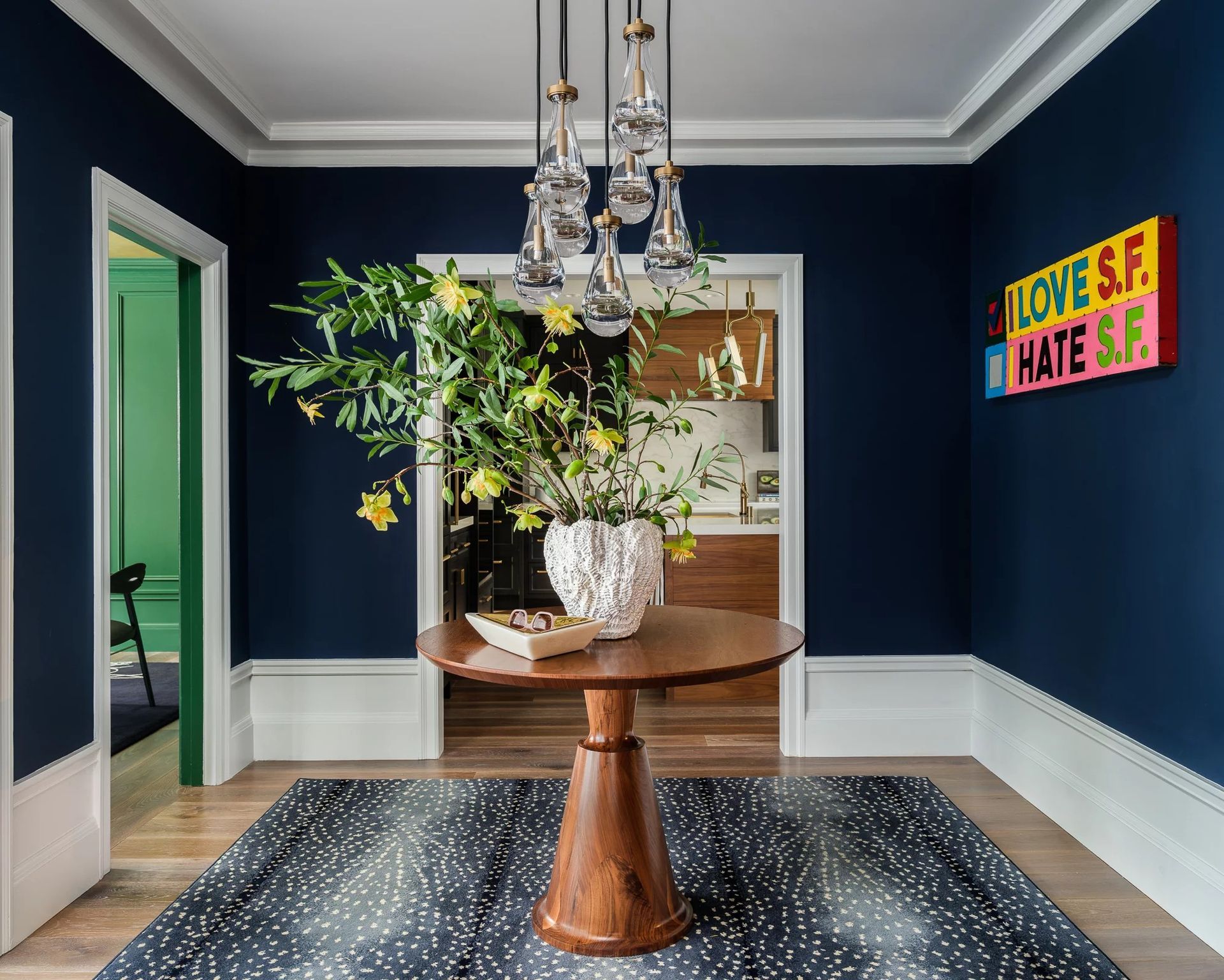 Navy blue entryway with a wooden table, a patterned rug, and a 