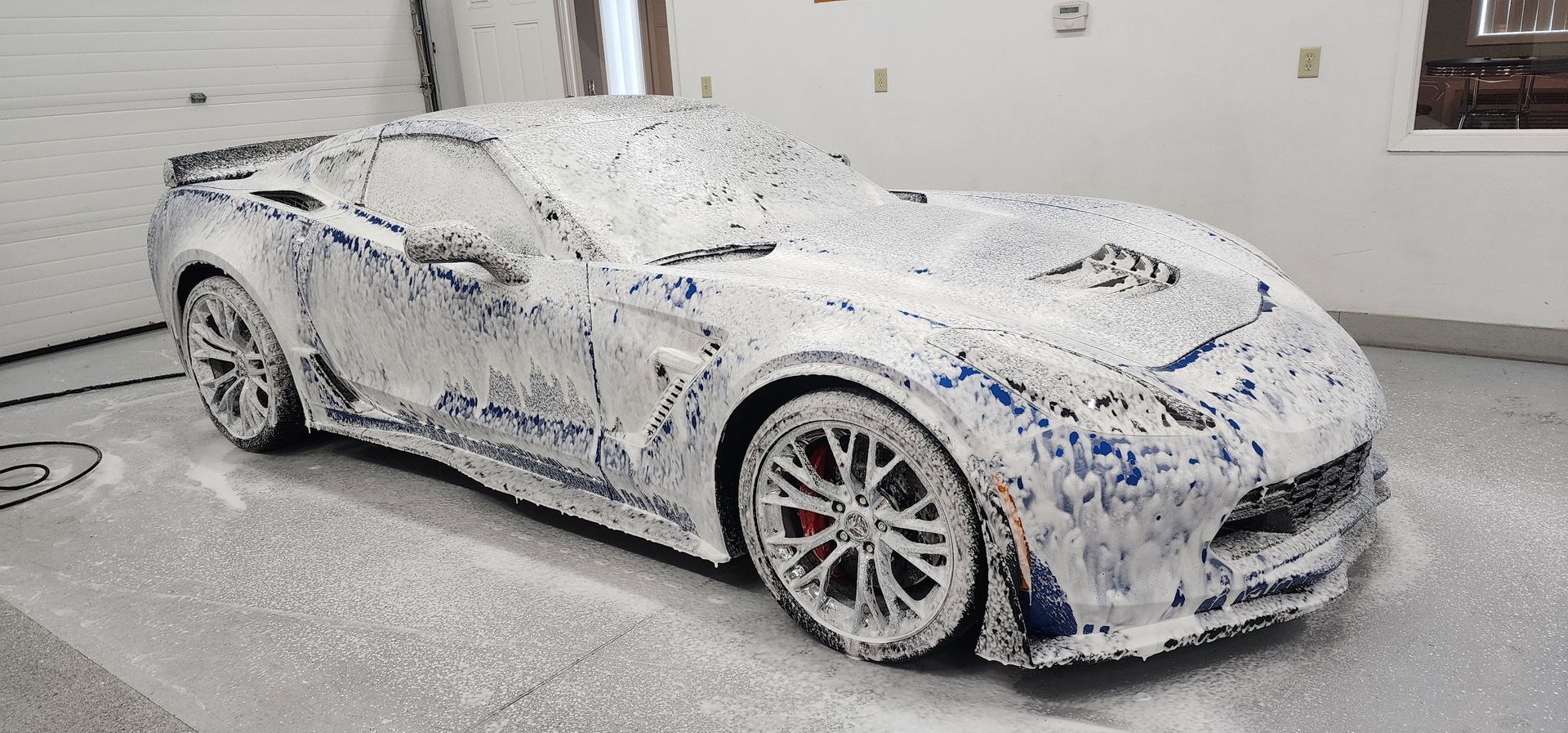 a car is covered in foam in a garage .