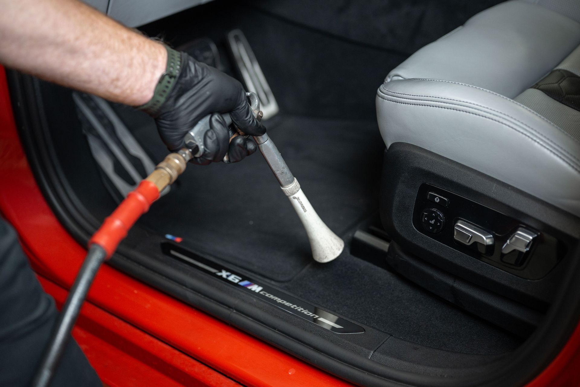 a person is cleaning the inside of a car with a vacuum cleaner .