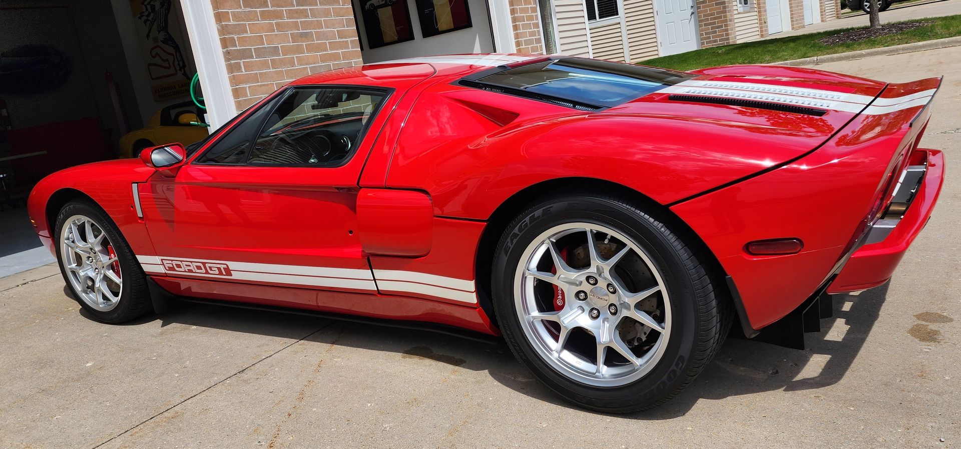 Red Ford GT sports car with white stripes.