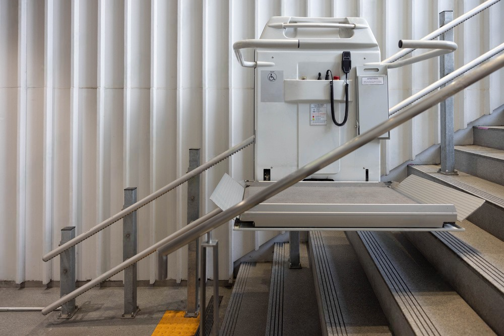 a stair lift is sitting on top of a set of stairs .