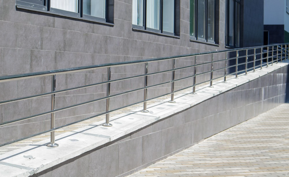 a ramp with a stainless steel railing on the side of a building .