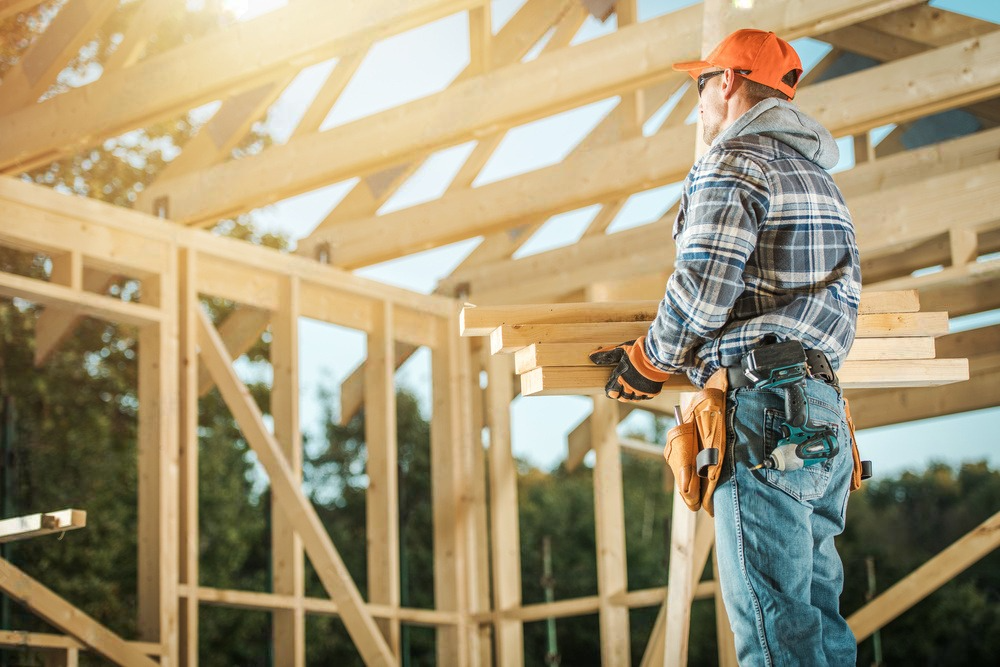 a construction worker is working on a wooden structure .