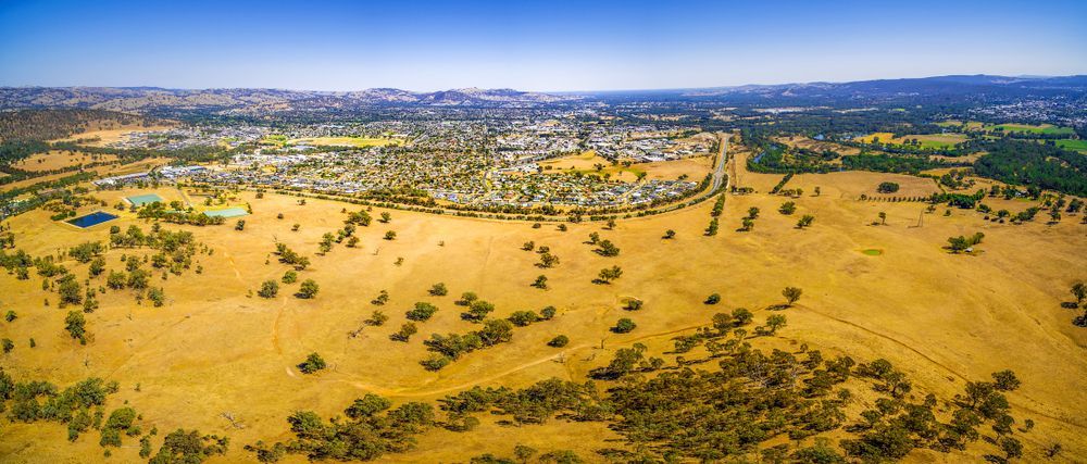 An Aerial View Of A Field With Trees And A City — James Fast Freight in Wodonga, NSW