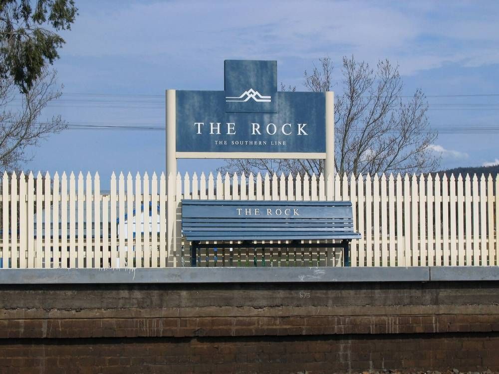 A Blue Sign That Says The Rock On It — James Fast Freight in The Rock, NSW