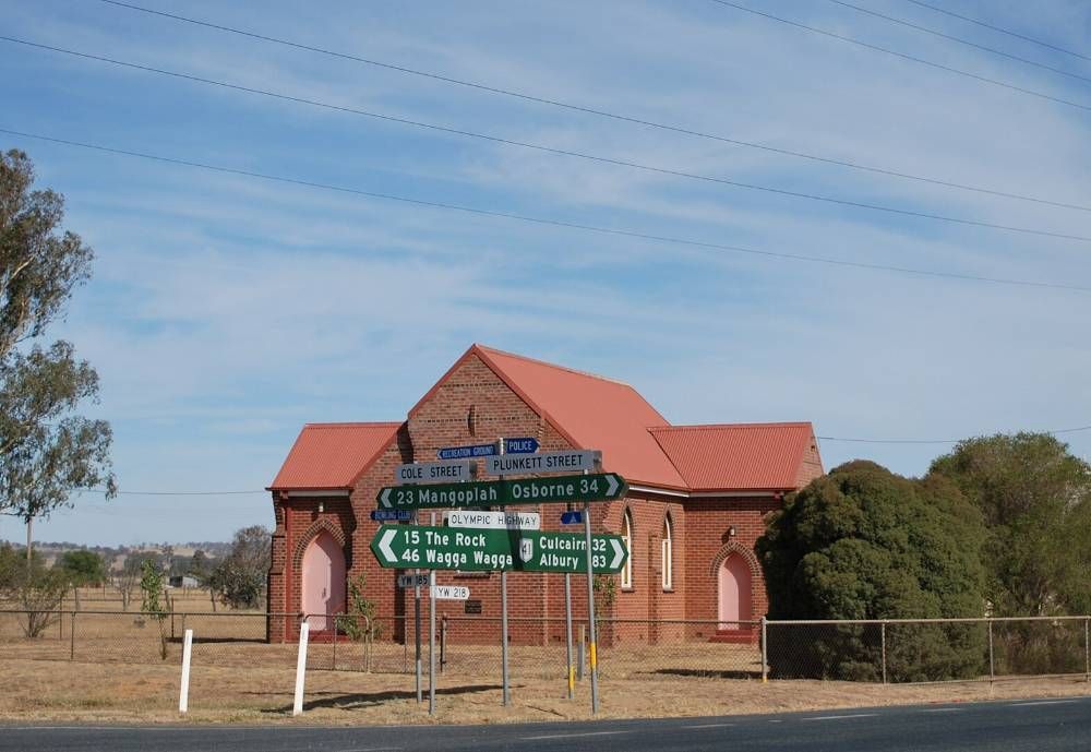 A Brick Building With A Red Roof And A Few Signs In Front Of It — James Fast Freight in Yerong Creek, NSW