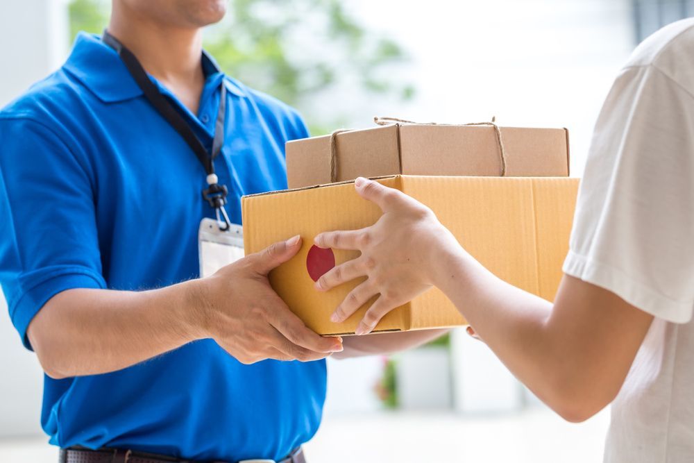 Man delivering packaged to the front door — James Fast Freight in Albury, NSW
