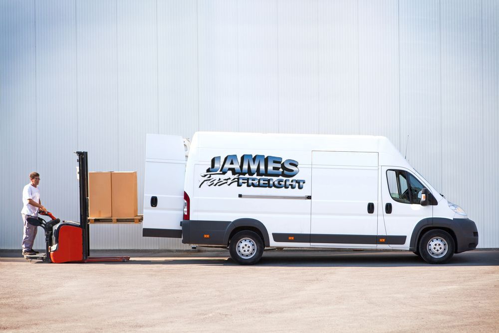 A Man Is Loading Boxes Into A White Van With A Forklift — James Fast Freight in Wagga Wagga, NSW