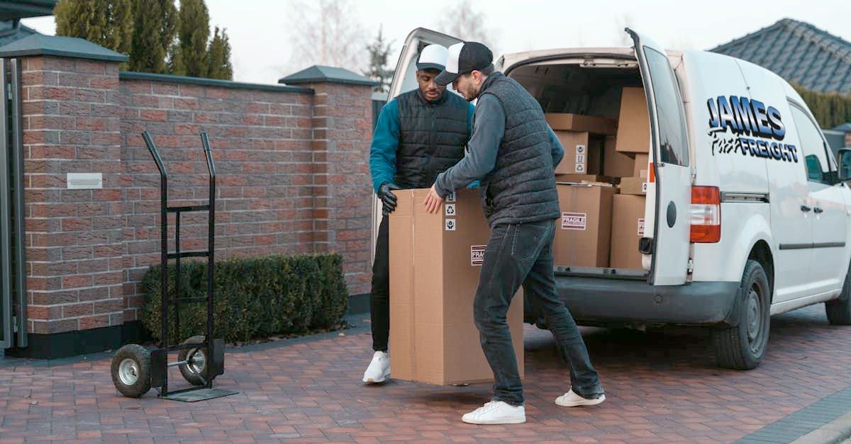 A Delivery Man Is Handing A Box To A Woman — James Fast Freight in Wodonga, NSW