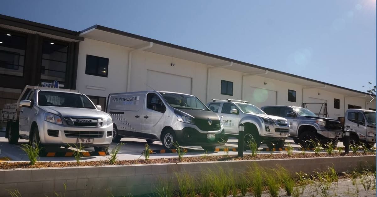 Vehicles parked outside a commercial building on a sunny day.