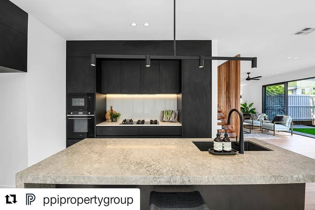 A Kitchen With Black Cabinets And A Granite Counter Top — Southeast Stone Pty Ltd In Gympie, QLD