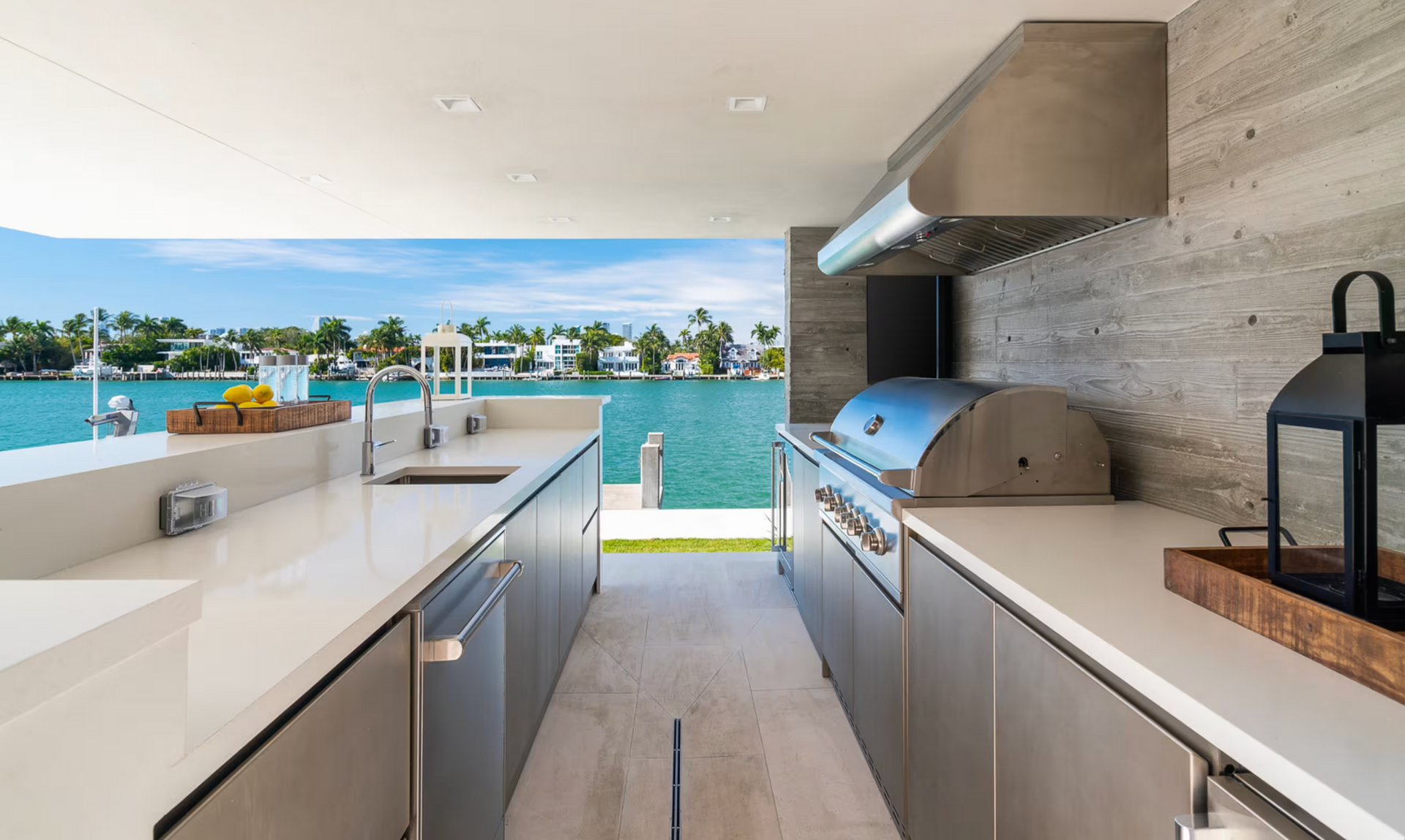 Modern outdoor kitchen beside a turquoise pool with ocean view and palm trees — Southeast Stone Pty Ltd In Caloundra West, QLD