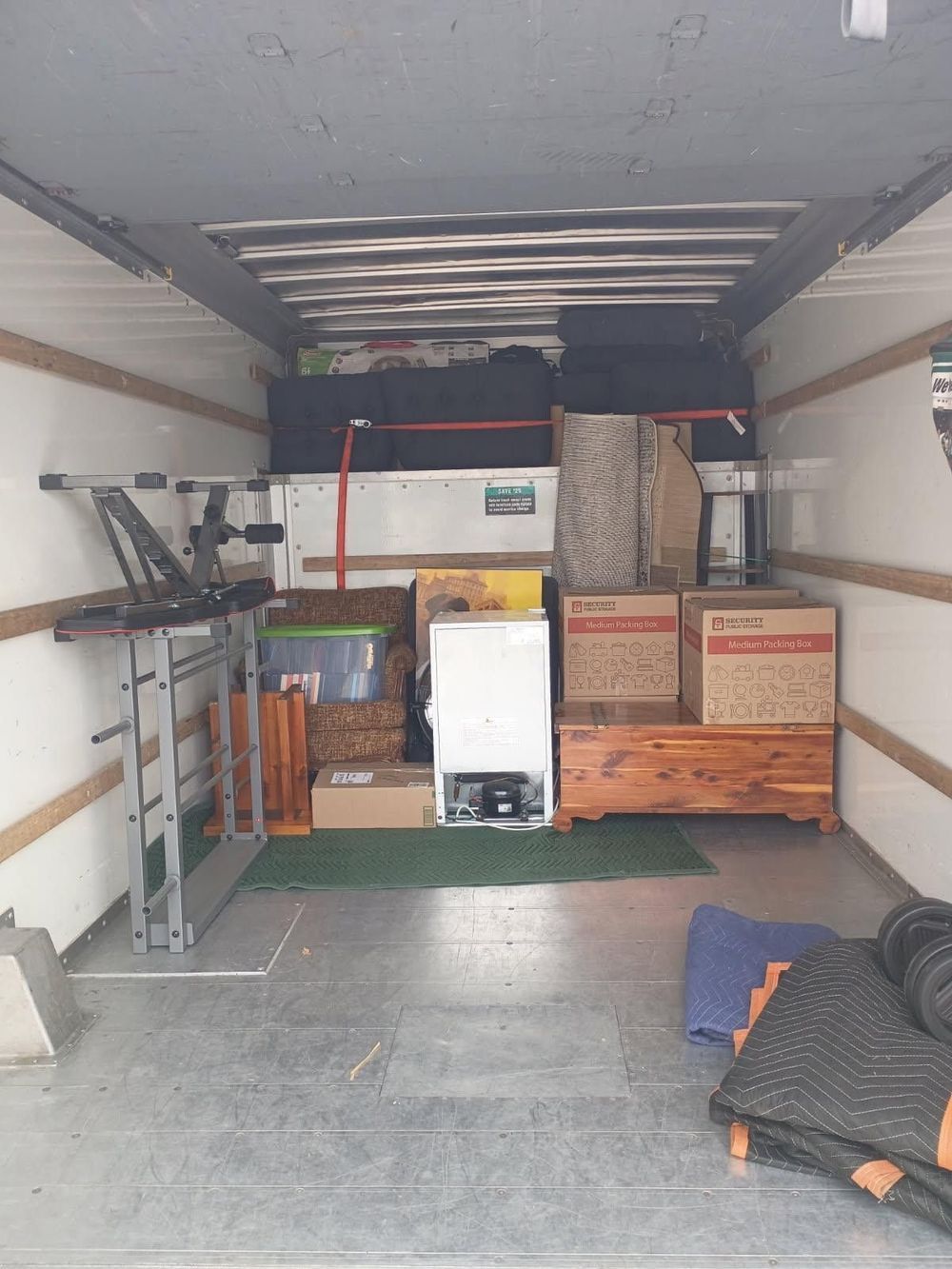 Cargo van interior packed with boxes, storage bins, and shelves for moving or delivery.