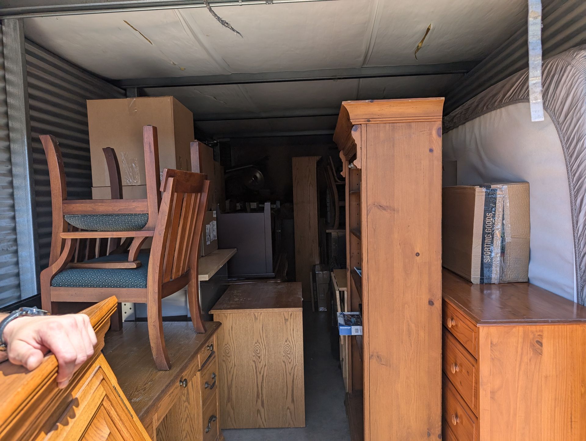 Packed moving truck interior with furniture, boxes, and cabinets stacked tightly inside