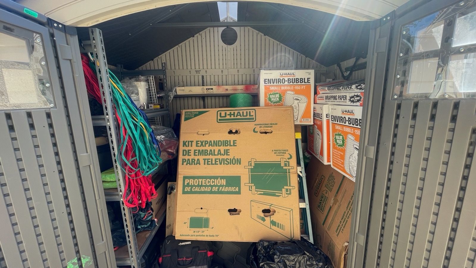 Stacked boxes and tangled cables inside a moving truck or storage van.