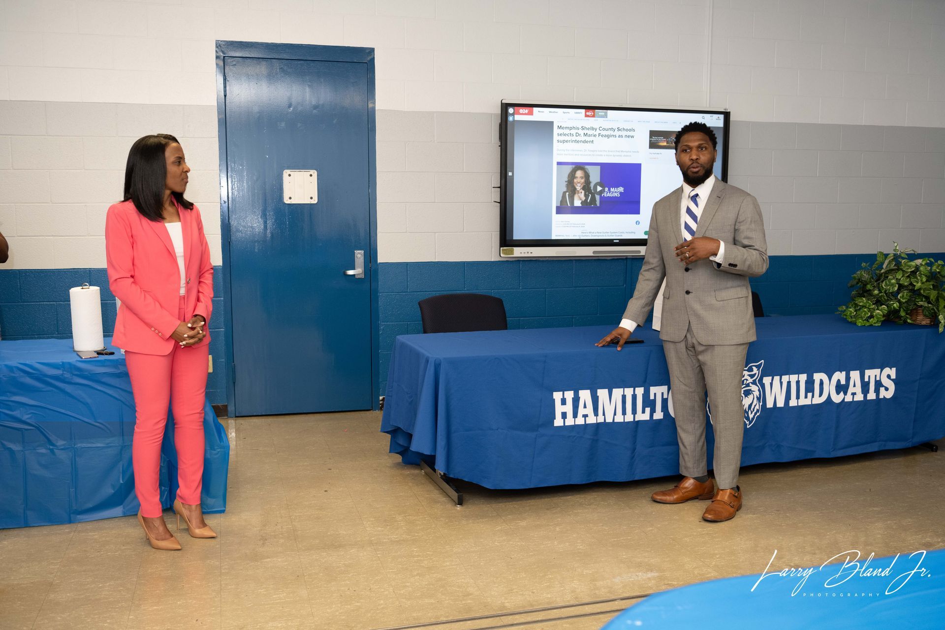 Two people in suits at a presentation.