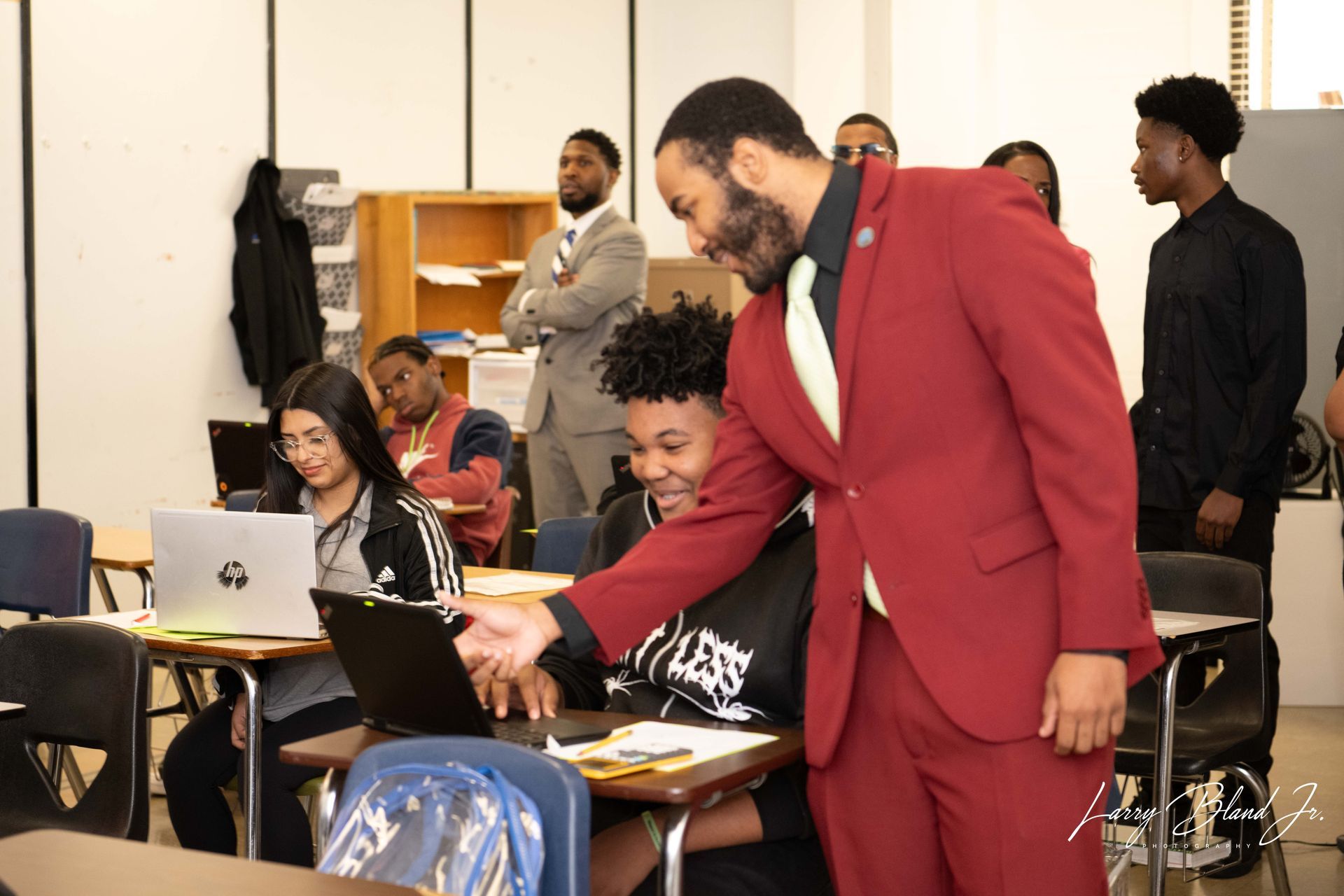 A man in red suit points at a laptop