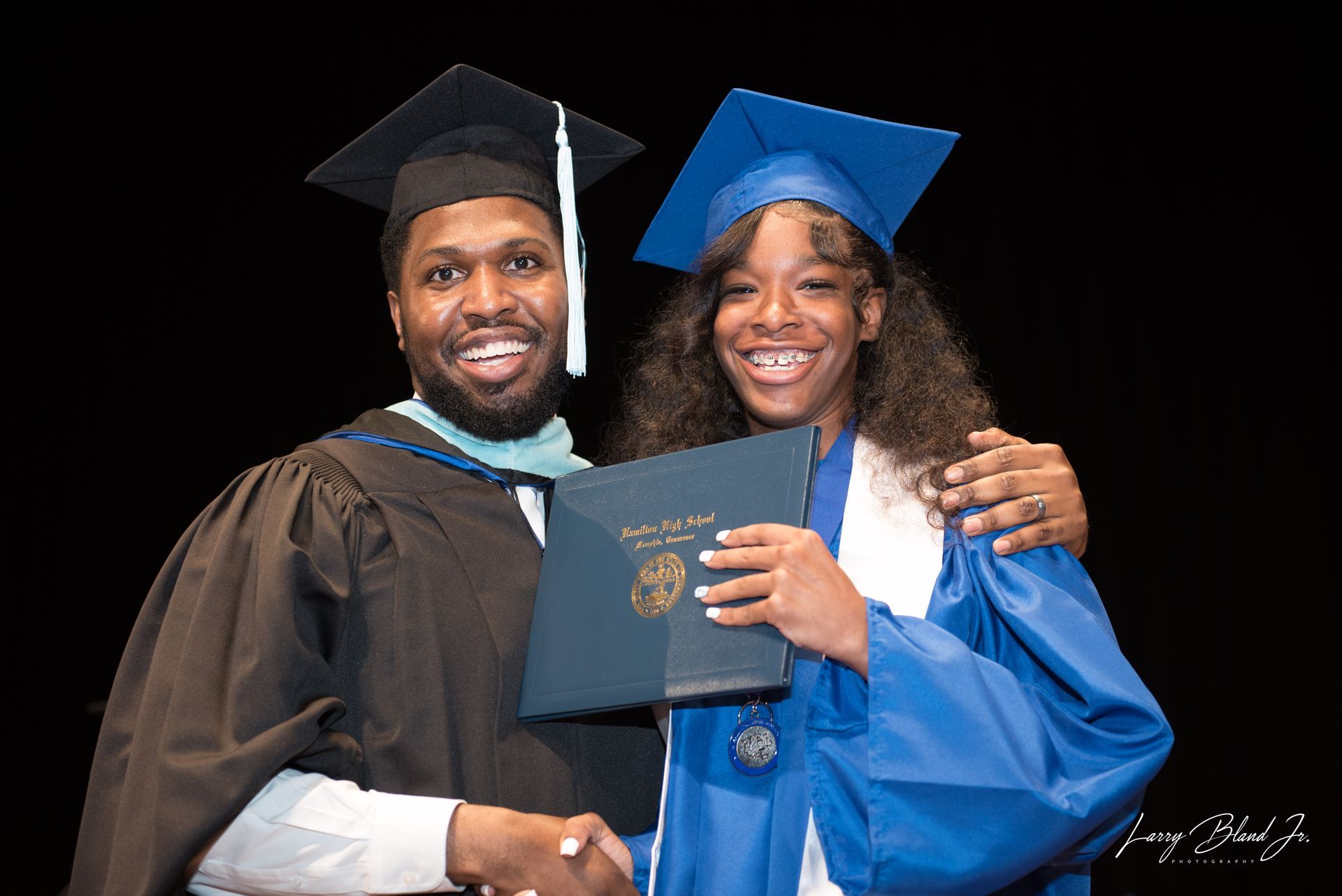Two people smiling at a graduation.