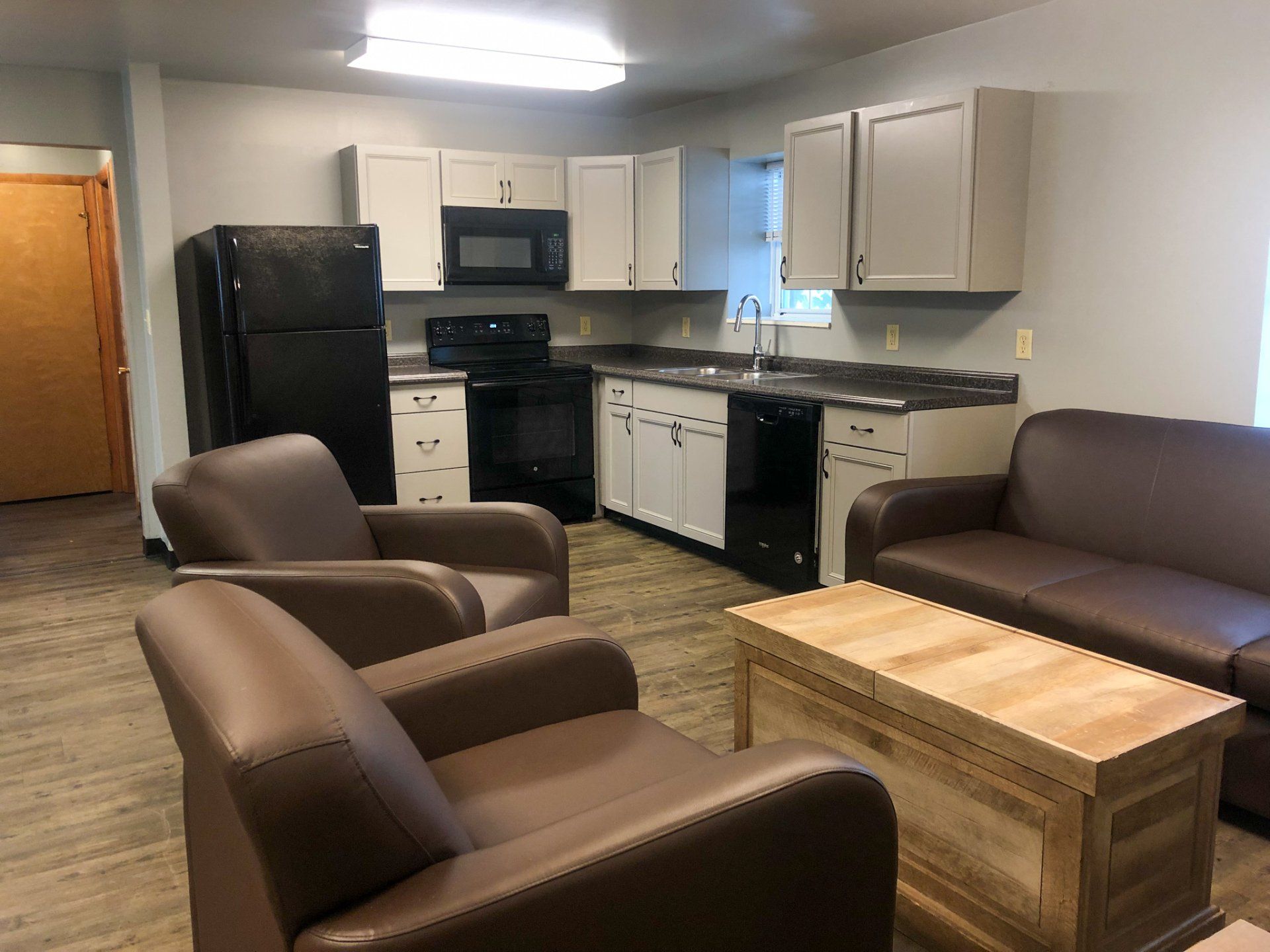 Living room with couch, chairs and view of kitchen