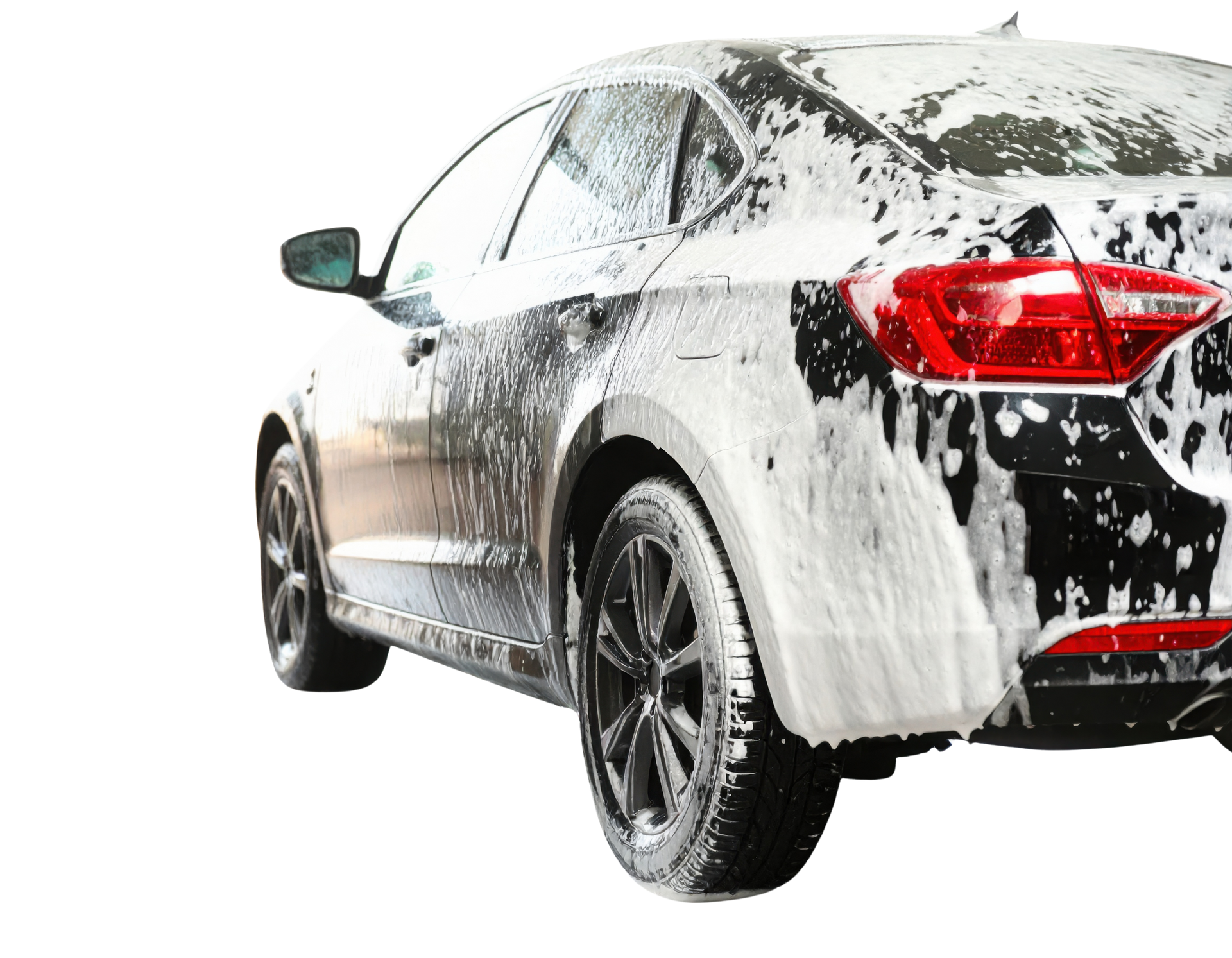 Black car covered in foamy soap suds, rear view.