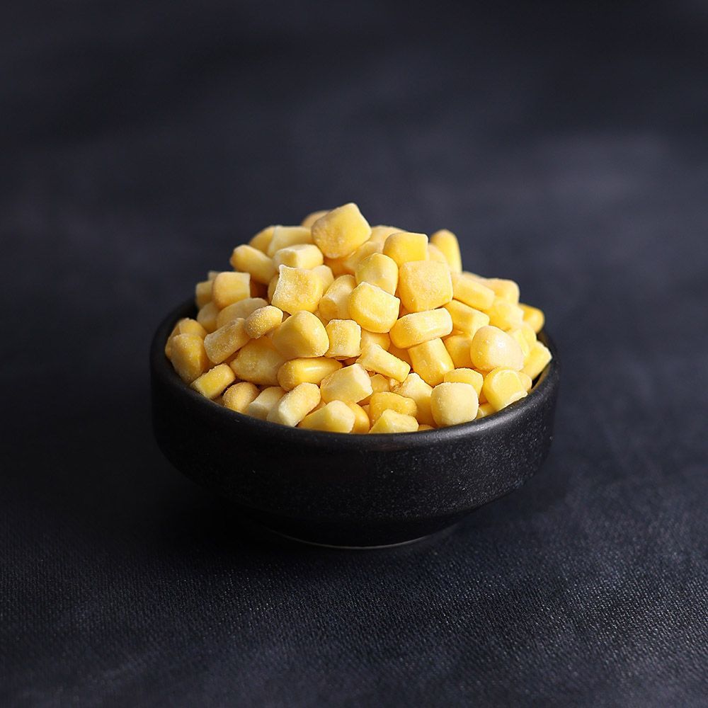 Black bowl filled with diced yellow fruit on a dark surface
