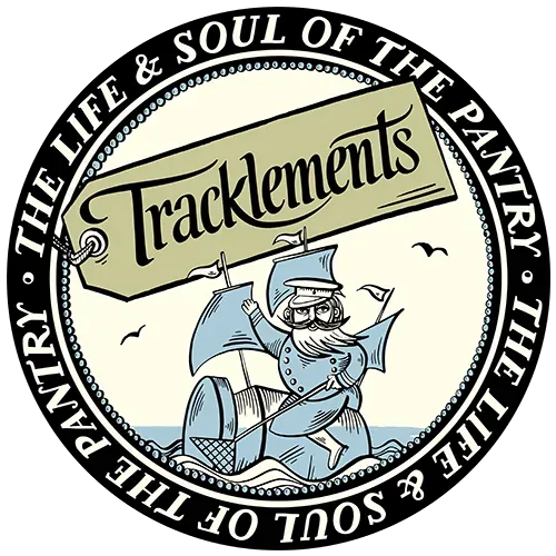 Circular Tracklements logo with a cartoon rat driving a cart, black-and-cream border, and brand name text