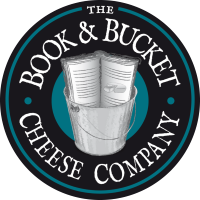Logo for The Book & Bucket Cheese Company with a bucket of cheese and an open book on a black circular background