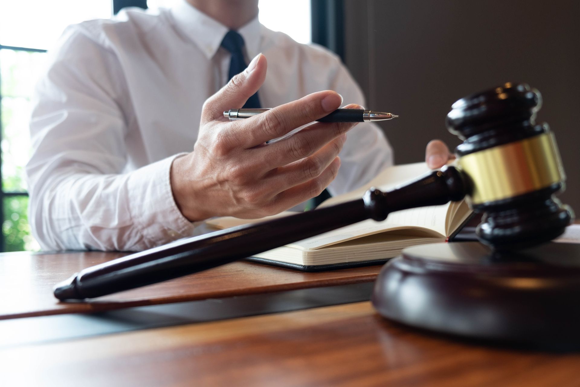 Lawyer holding a gavel over documents in a courtroom setting
