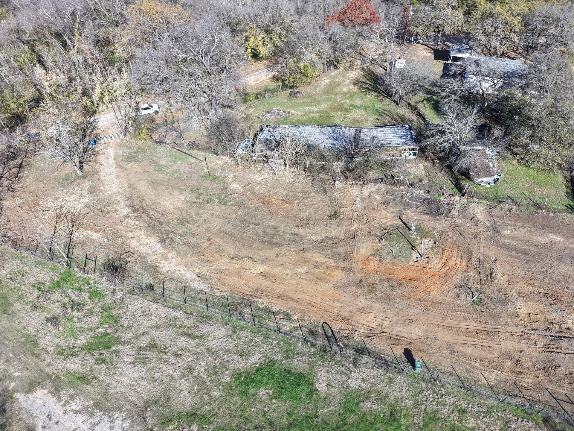 Dry, grassy hillside with scattered shrubs and rocks under bright daylight