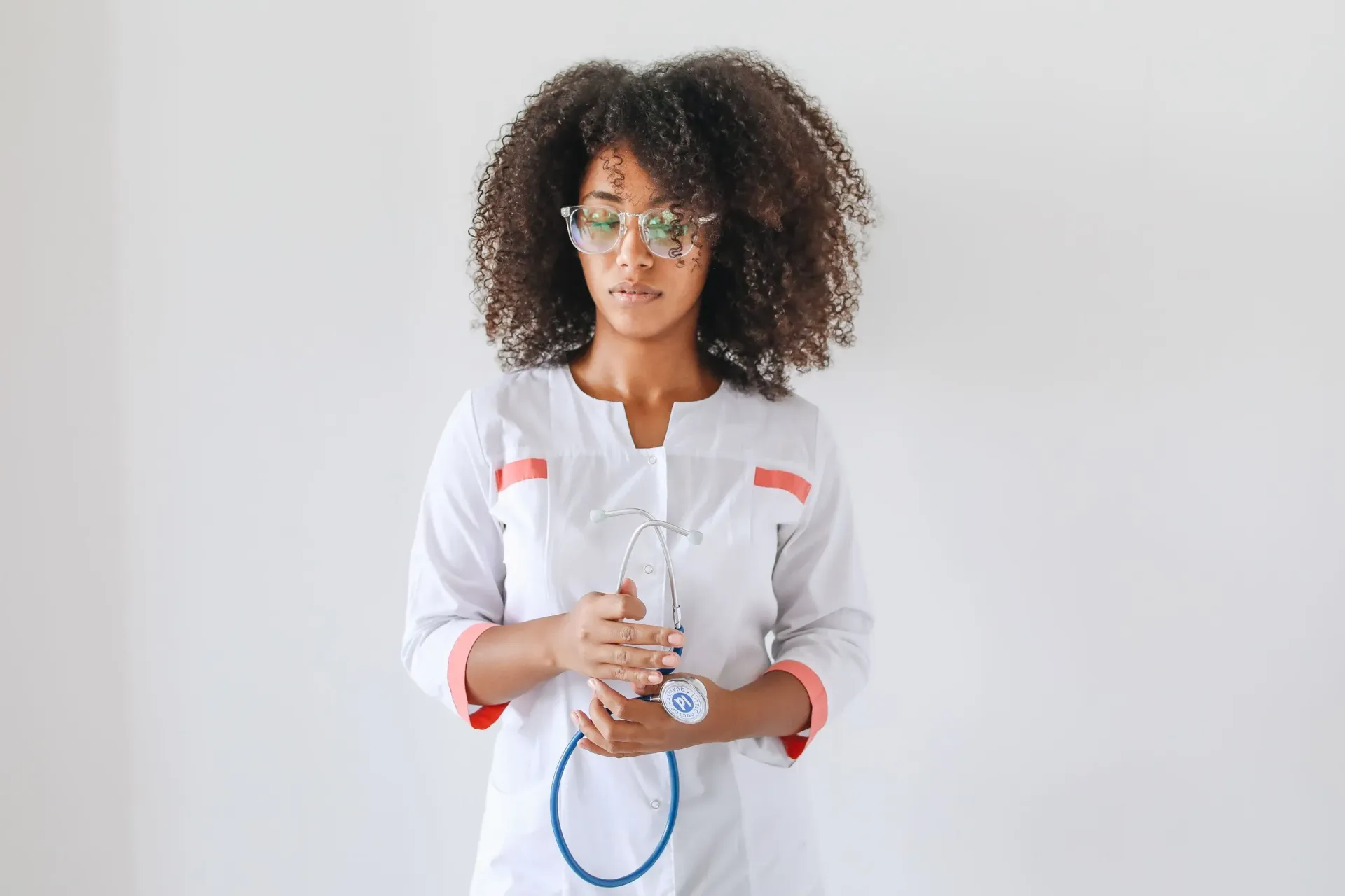 Person holding a blue medical tube against a plain white background