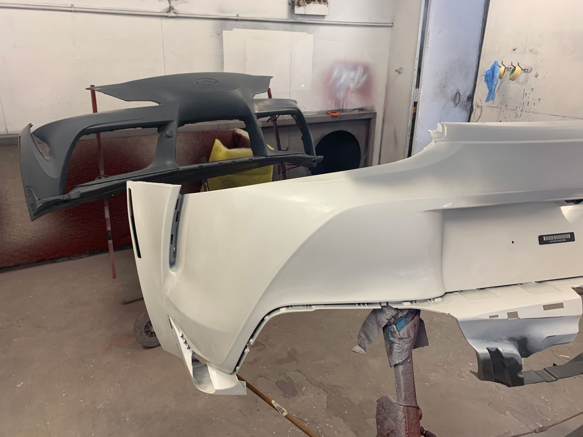 A car bumper is being painted in a garage