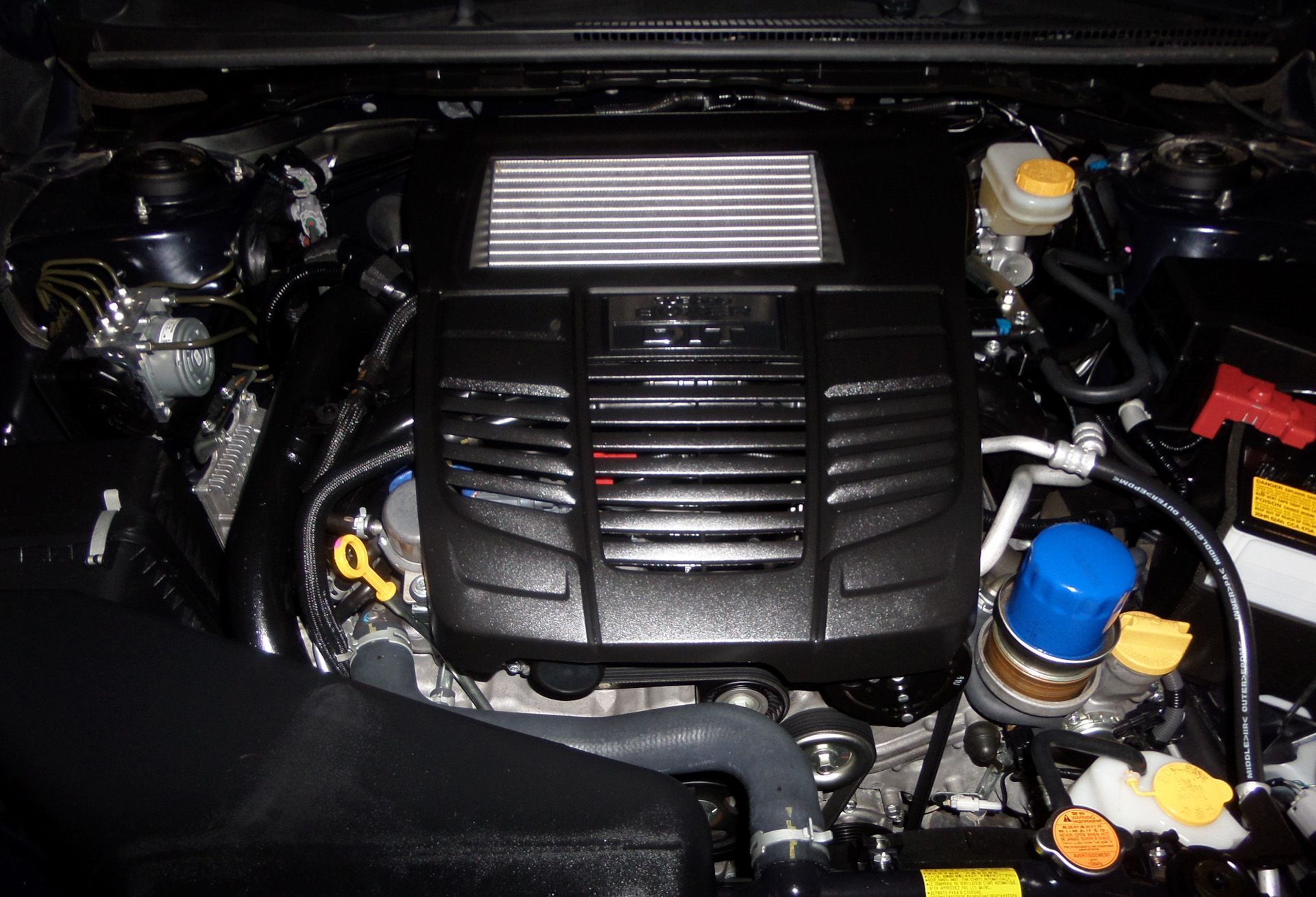 A close up of a car engine with a blue cap on it