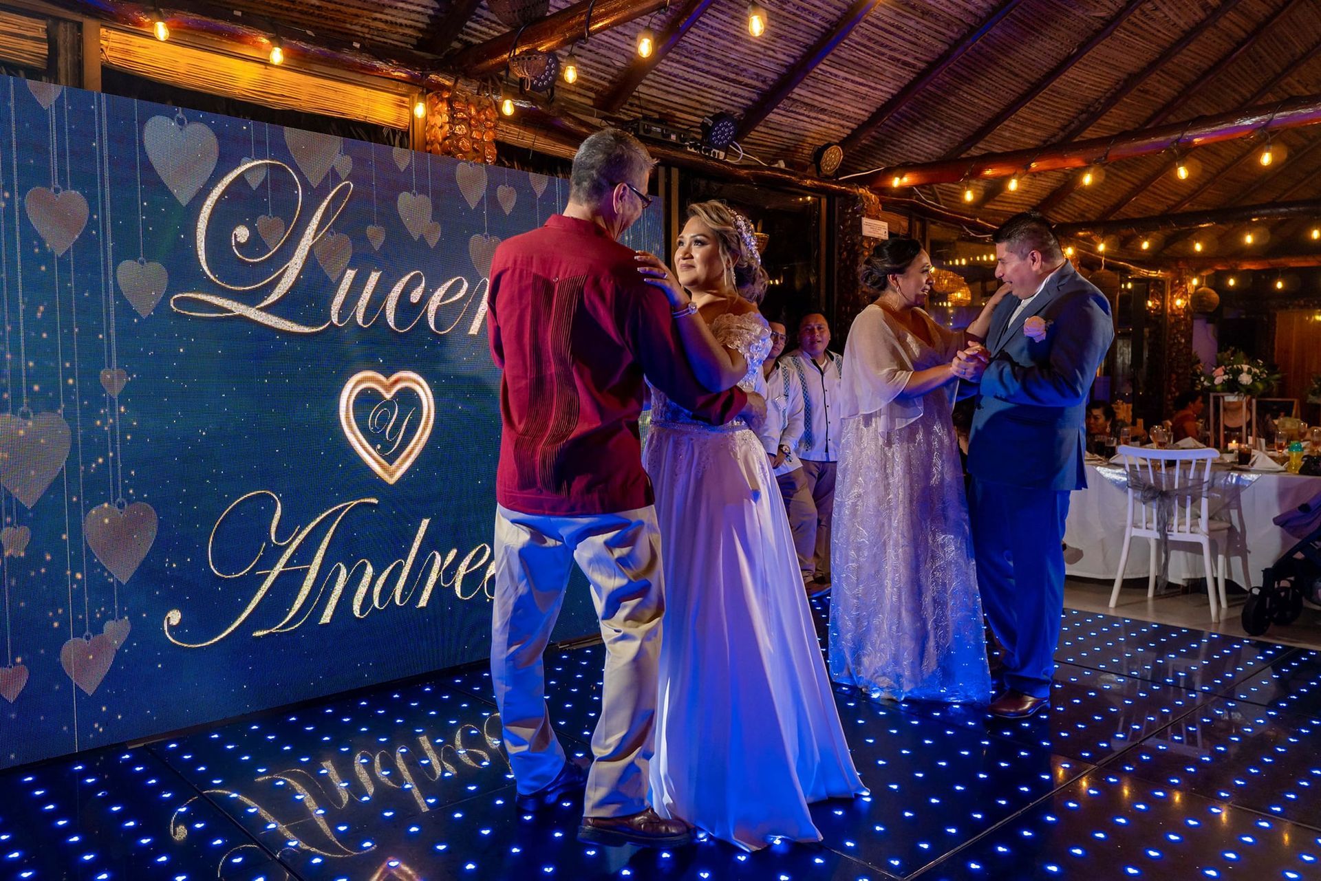 Una novia y un novio están bailando en una pista de baile en la recepción de su boda.