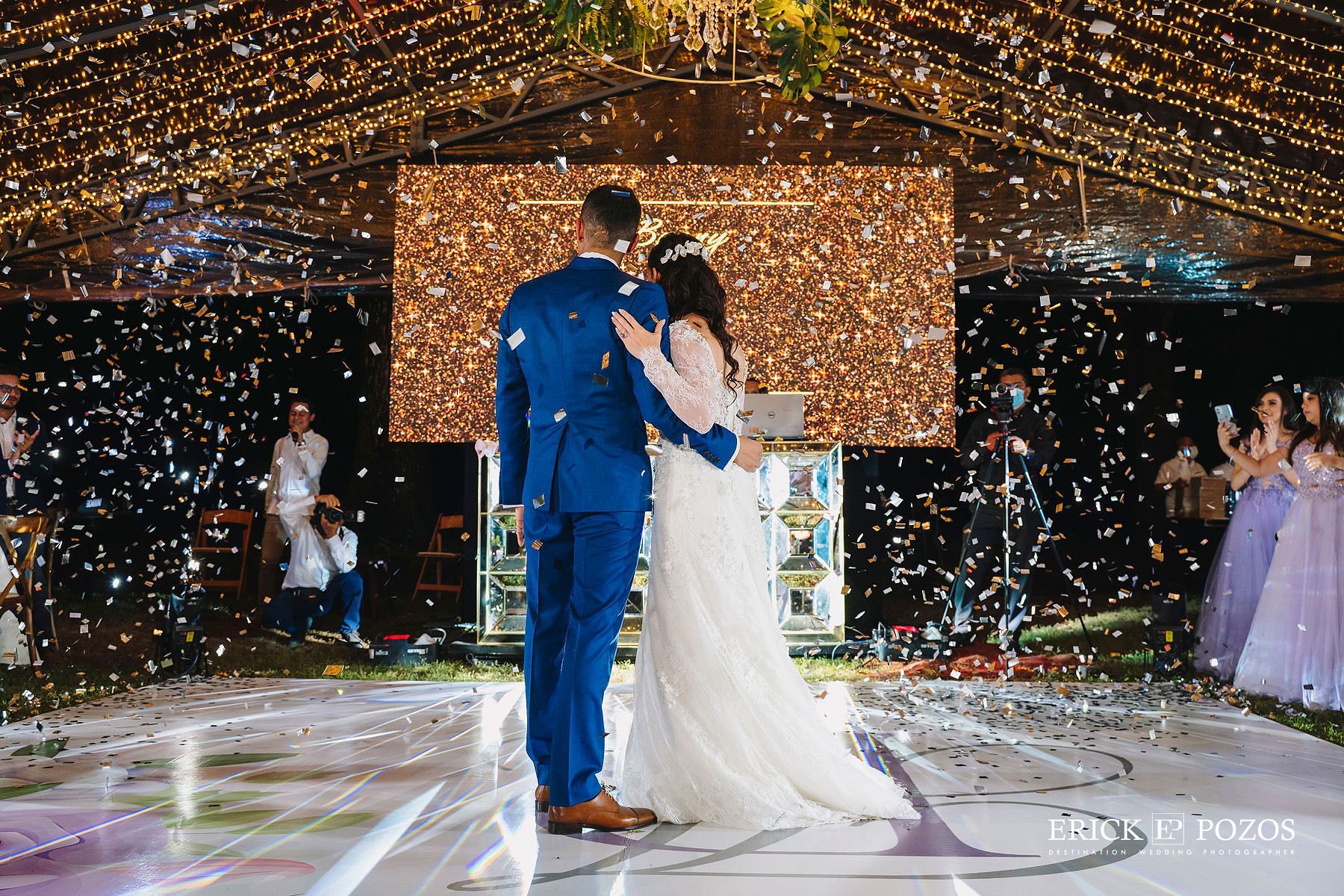 Una novia y un novio están bailando en una pista de baile en la recepción de su boda.