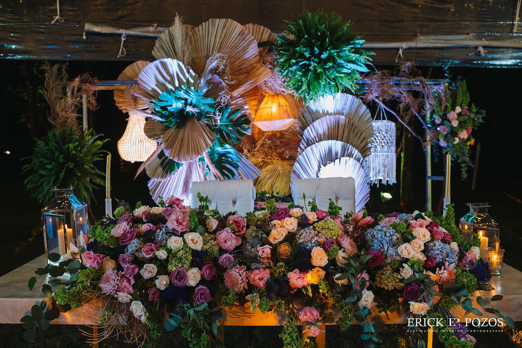 Una mesa larga con muchas flores y velas.