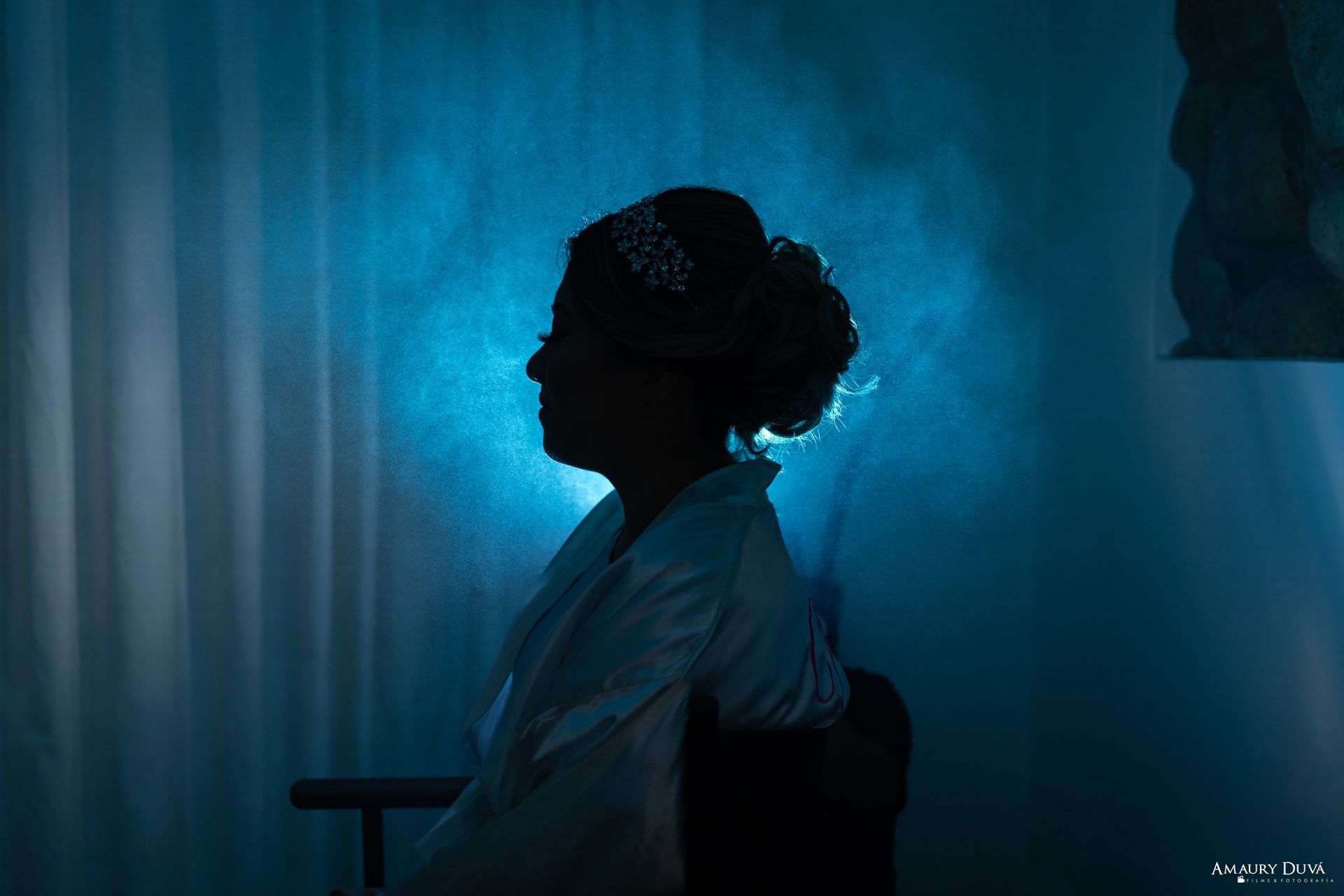 Una silueta de una mujer sentada en una silla con un fondo azul.