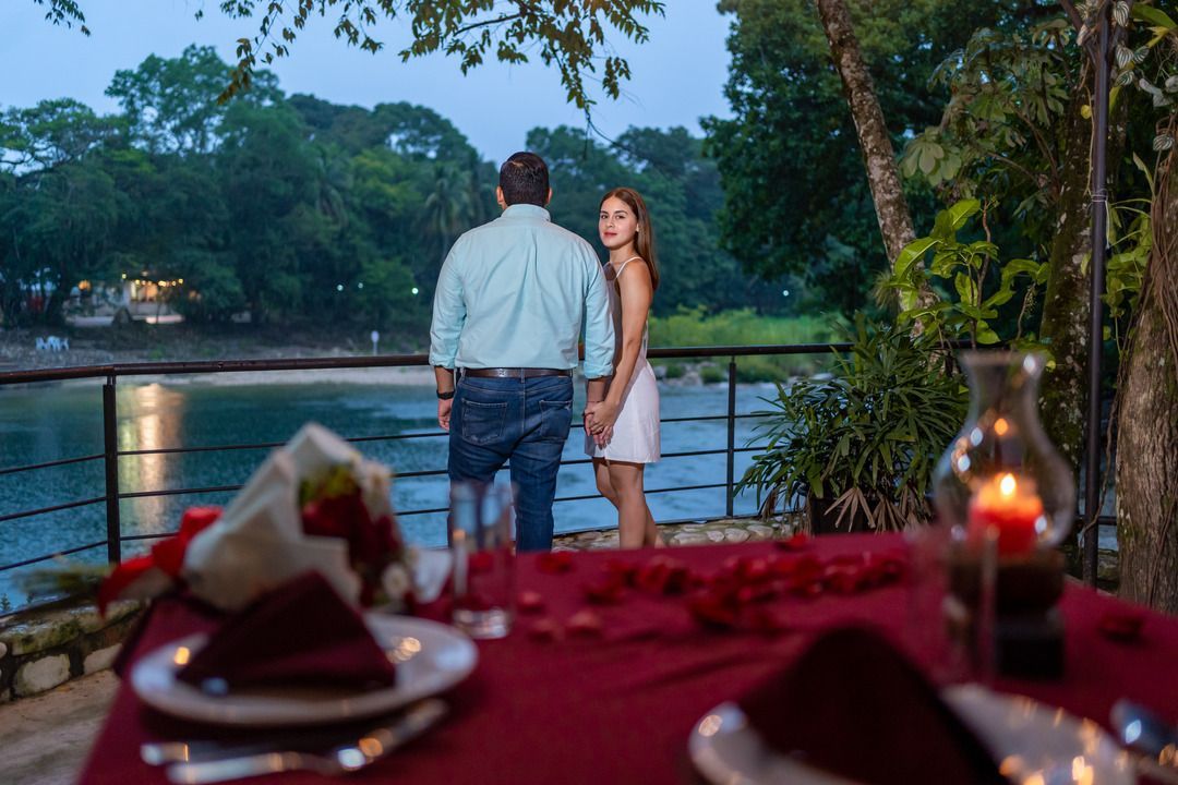 Un hombre y una mujer están de pie en una mesa con vistas a un lago.