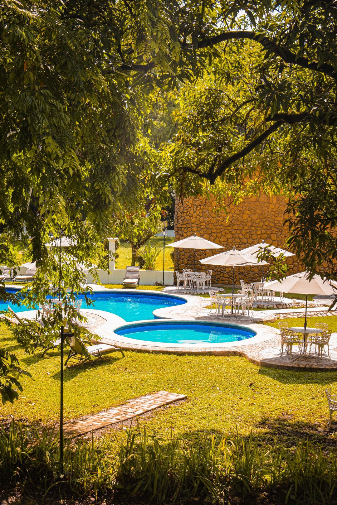 Una gran piscina rodeada de tumbonas y sombrillas.