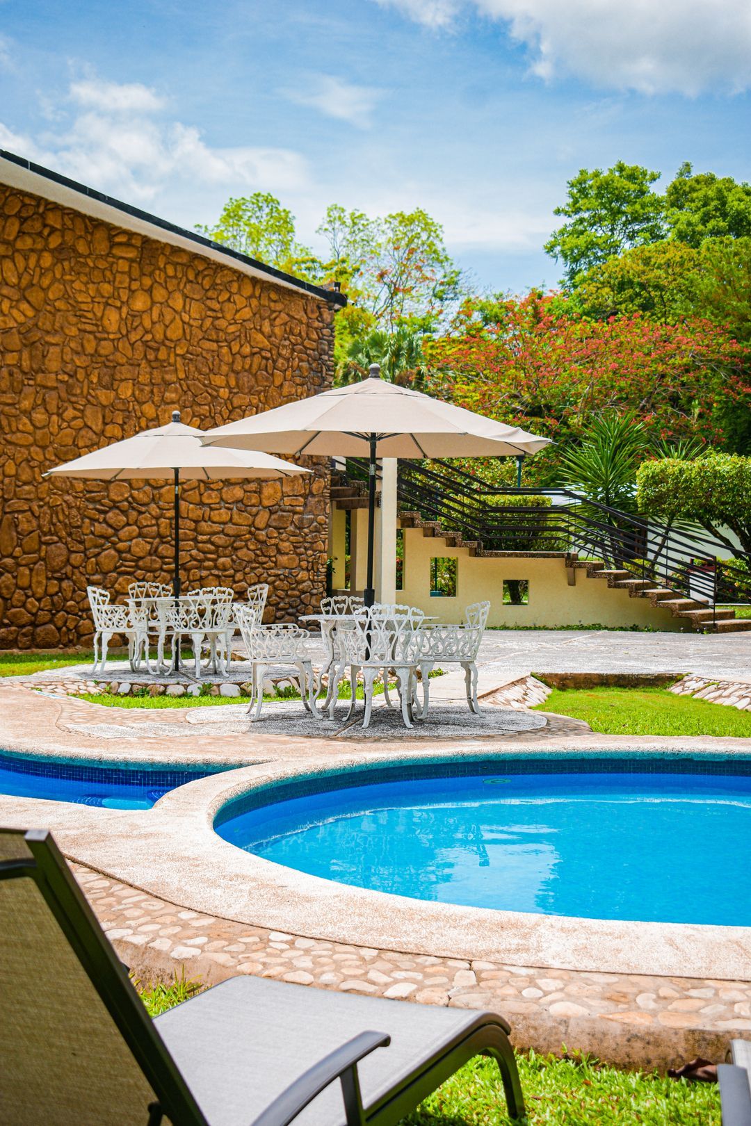 Una gran piscina con sombrillas y sillas a su alrededor.