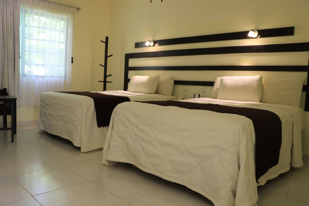 Una habitación de hotel con dos camas y una ventana.