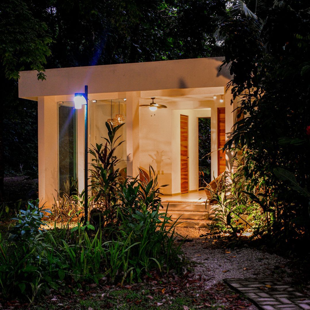 Una pequeña casa en medio de un bosque por la noche.