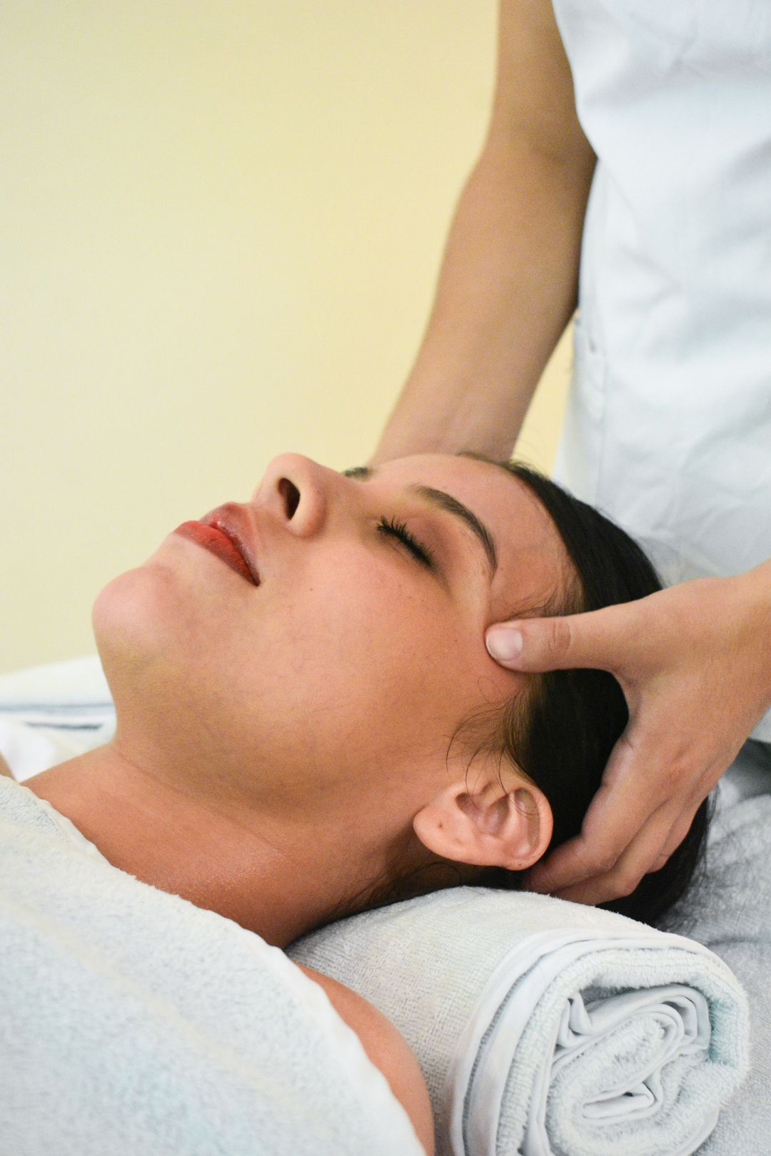 Una mujer está recibiendo un masaje de cabeza en un spa.