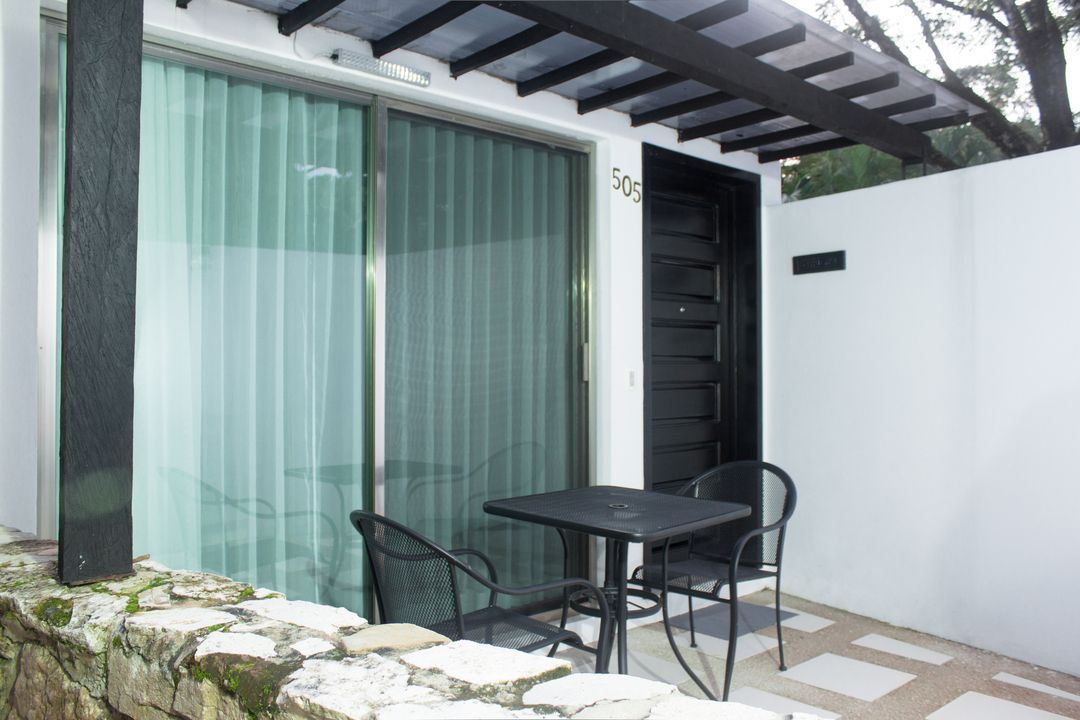 Un patio con una mesa y sillas frente a una puerta corrediza de vidrio.