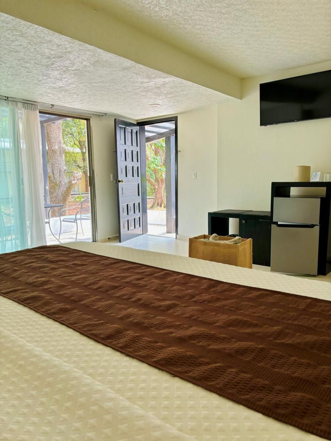 Una habitación de hotel con una cama grande y una alfombra marrón.