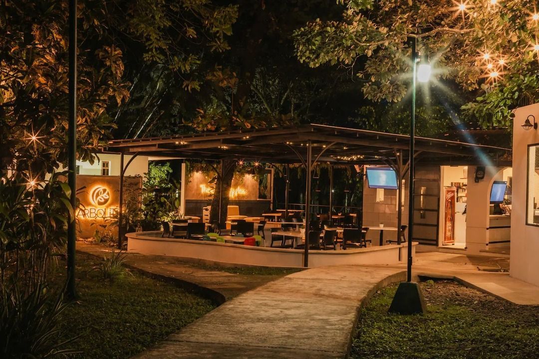 Un restaurante con mesas y sillas está iluminado por la noche.
