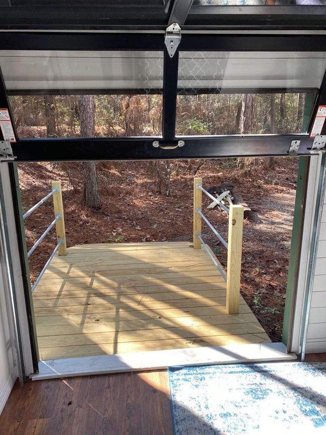 A view of a wooden deck from inside a garage door.